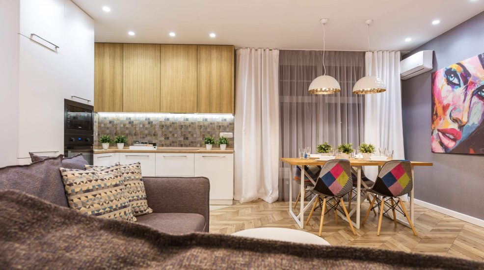 Cozinha integrada com mesa de jantar e sala de estar, mostrando como mobiliar um apartamento pequeno